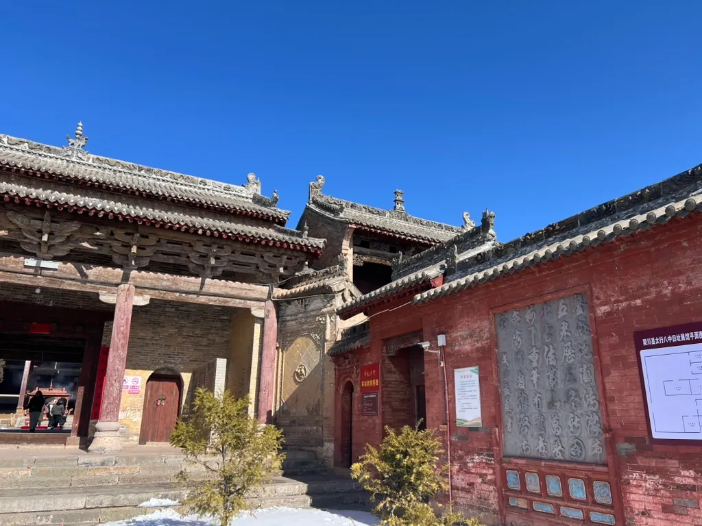 院内一侧,左边是殿宇前廊,右边是砖墙上嵌着书法石刻的配房