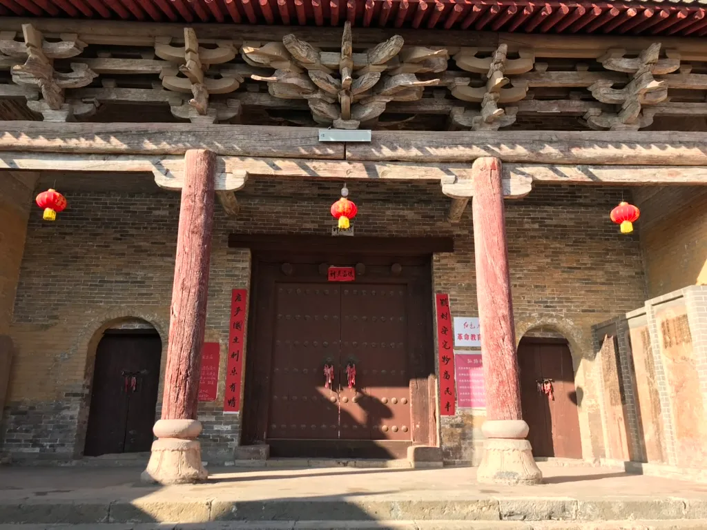 殿宇檐下的木构斗栱和额枋,下方是两根石础木柱